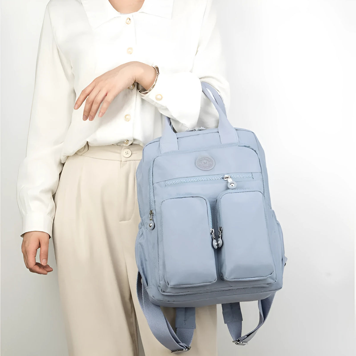 Women's waterproof nylon travel backpack in grey, showing front external pocket and organisational interior.