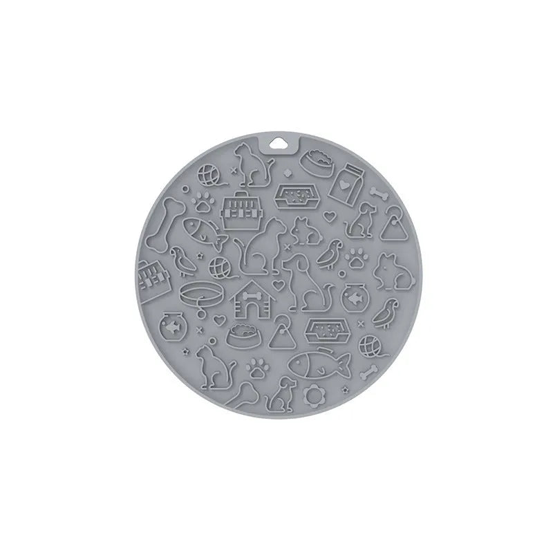 Round blue silicone pet licking mat with textured surface and a clear central suction cup, shown on a tile floor.