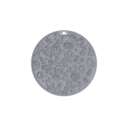 Round blue silicone pet licking mat with textured surface and a clear central suction cup, shown on a tile floor.