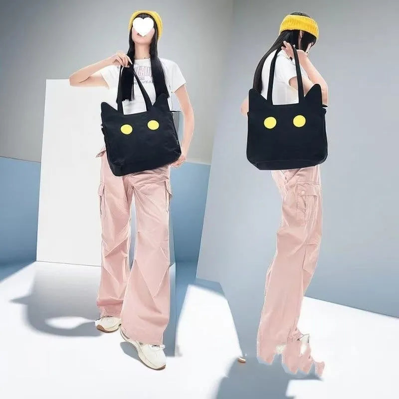 Black cat-shaped nylon tote bag with medium-soft structure, nylon lining, and sandwich zipper pocket, 34cm x 13cm x 27cm.