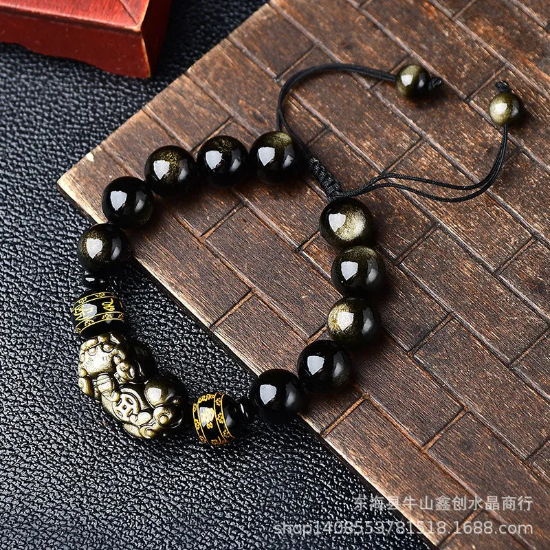 Handmade golden obsidian Pi Xiu bracelet with Chinese zodiac design on wrist.