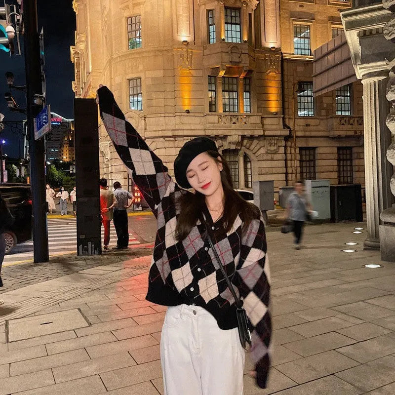 Long sleeve knitted cardigan in a light khaki colour, shown open over a white top, demonstrating its relaxed fit and medium weight.