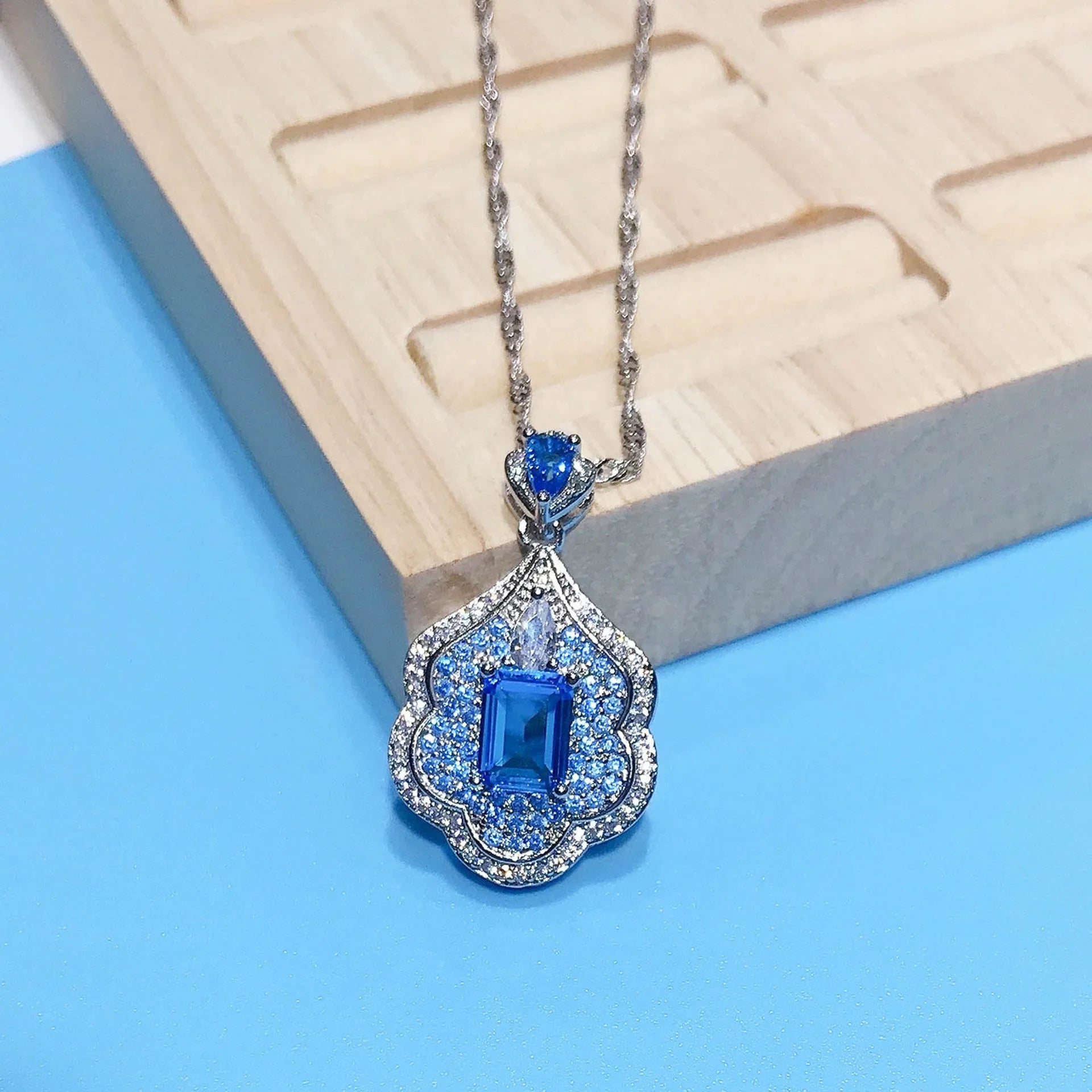Geometric sea blue copper pendant charm on a white background.