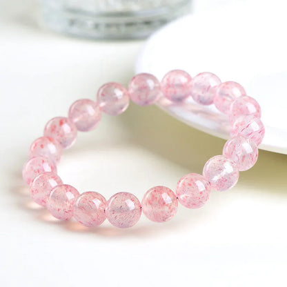 Unisex white strawberry quartz bracelet with round 10mm geometric beads on a string.