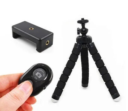 Black flexible octopus tripod with legs wrapped around a pole, holding a smartphone with a clip mount.