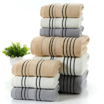 Household pure cotton towel set showing one large bath towel and two smaller hand towels in a neutral colour like grey or khaki.