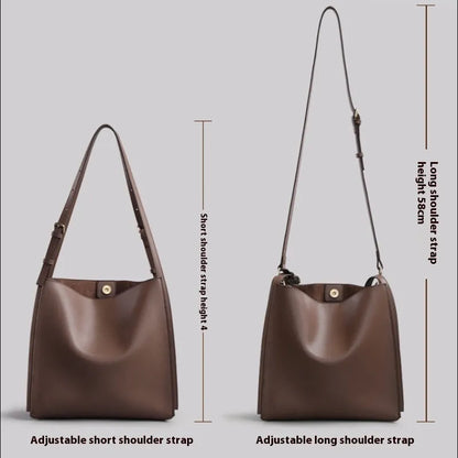 Brown genuine leather women's bucket-style commuter bag with double shoulder straps showing internal compartments
