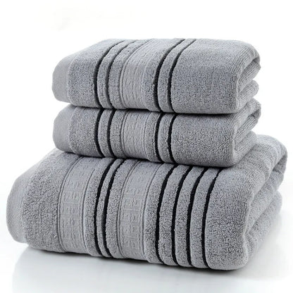 Household pure cotton towel set showing one large bath towel and two smaller hand towels in a neutral colour like grey or khaki.