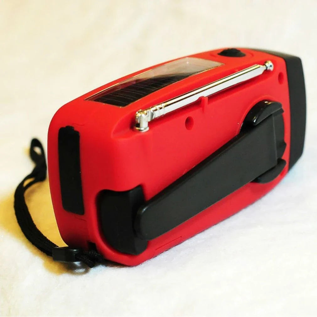 Portable solar and hand-cranked USB charging radio flashlight with LED illumination for outdoor adventures and emergency preparedness