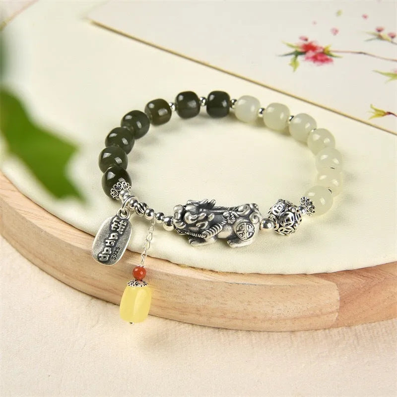 Close-up of a retro-style sterling silver coin bracelet with natural Hetian jade beads for women.