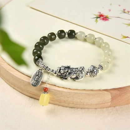 Close-up of a retro-style sterling silver coin bracelet with natural Hetian jade beads for women.