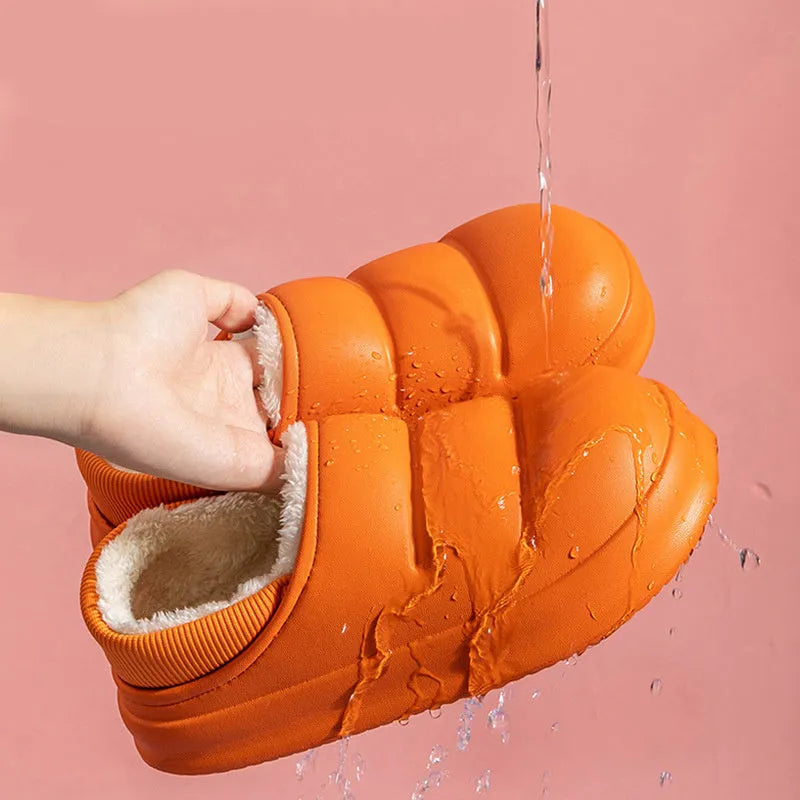 Pair of yellow waterproof EVA slippers with plush lining and a textured non-slip sole on a wooden floor.