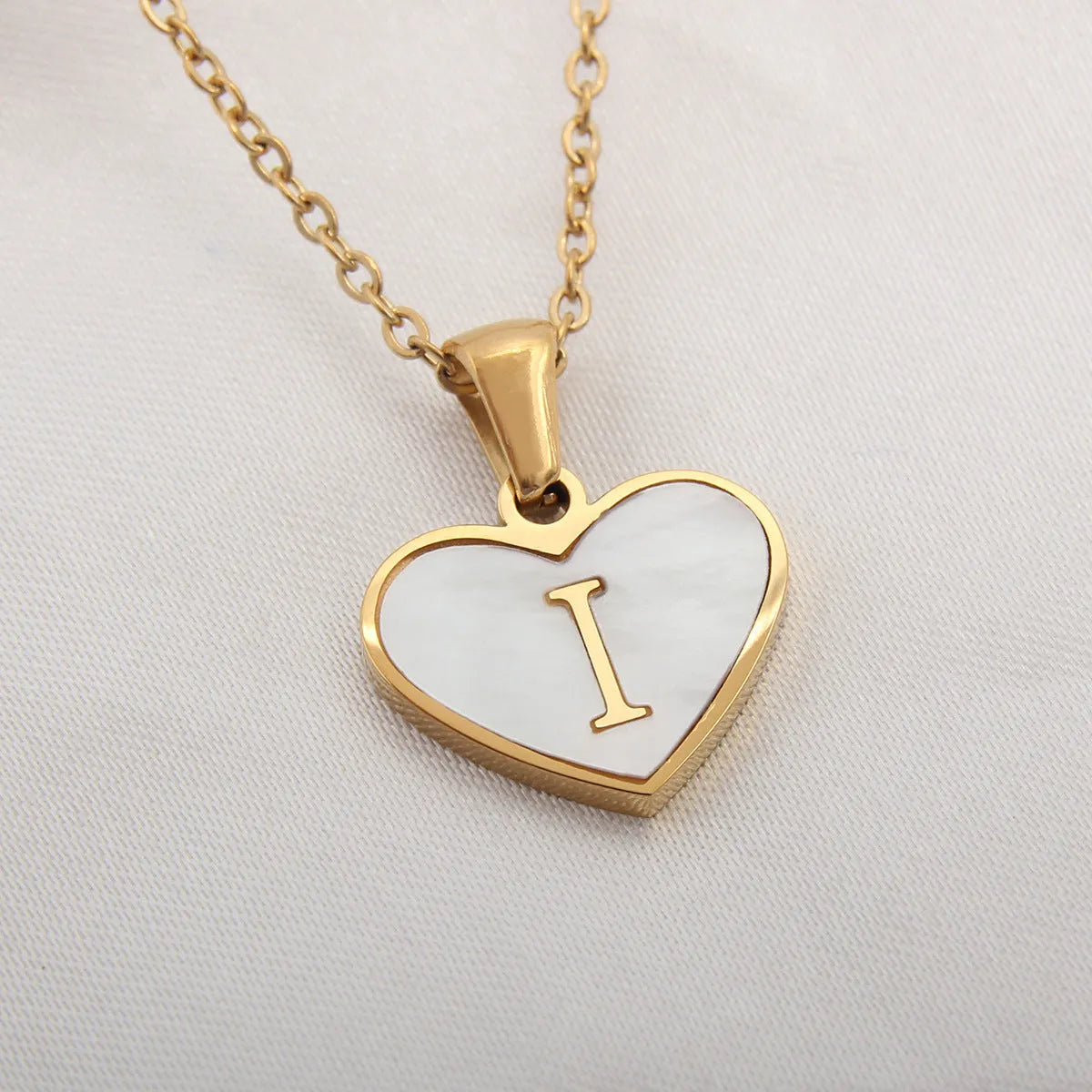 Gold-plated heart necklace with white shell pendant showing letter personalisation option