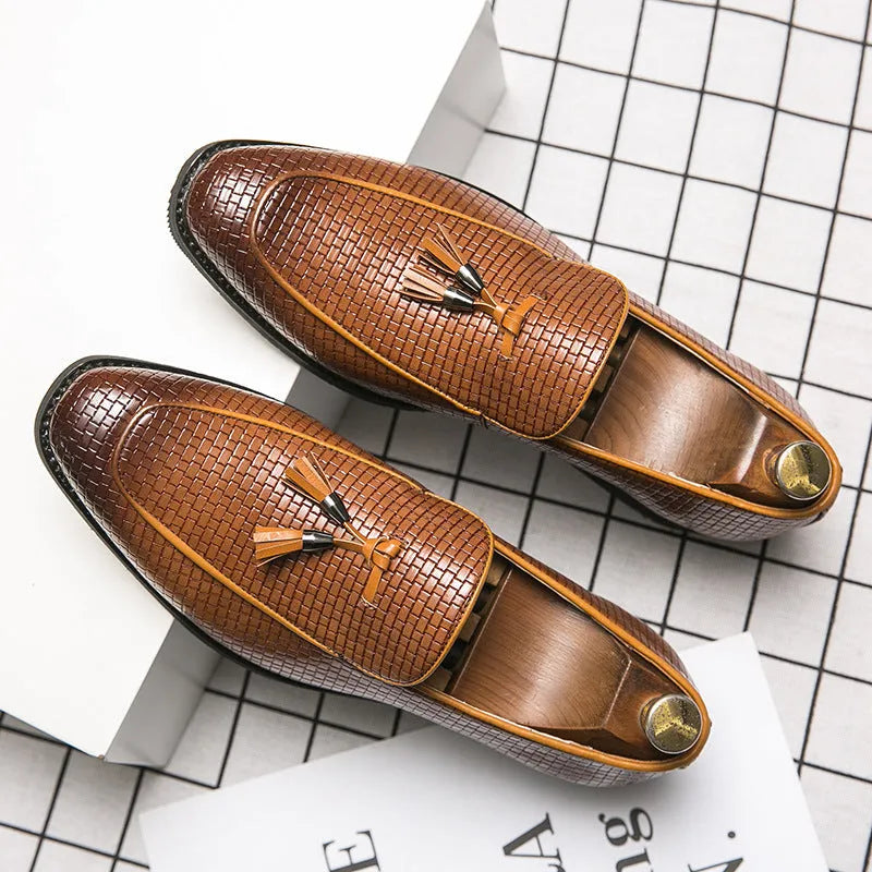 Men's black pointed toe slip on shoes with a tassel detail on the upper.