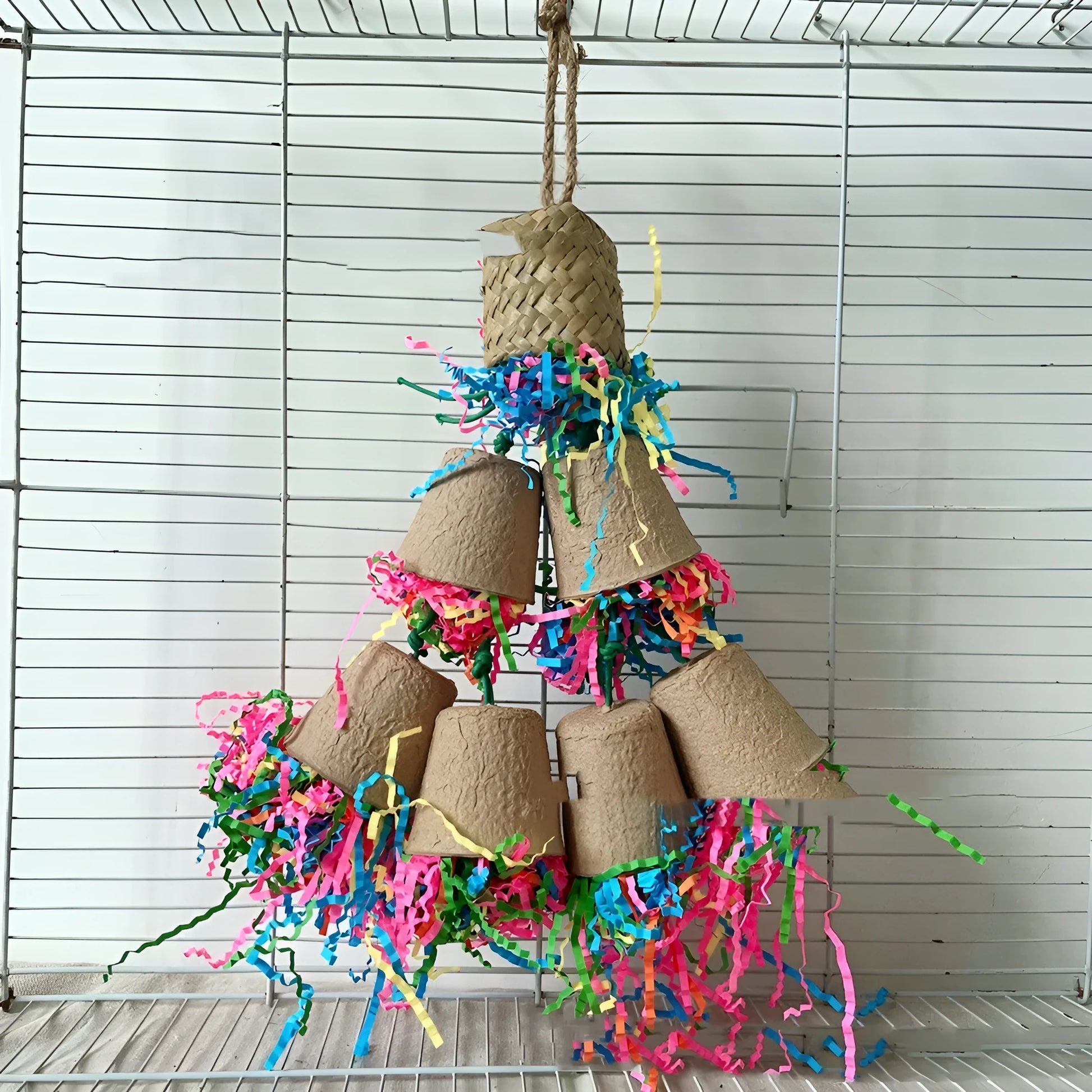 Natural palm leaf parrot chewing toy hanging with woven paper cup design.