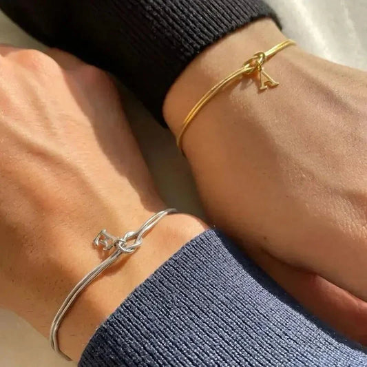 Elegant letter charm bracelets for women in gold and silver tones, featuring a delicate snake chain design and personalised letter charms.