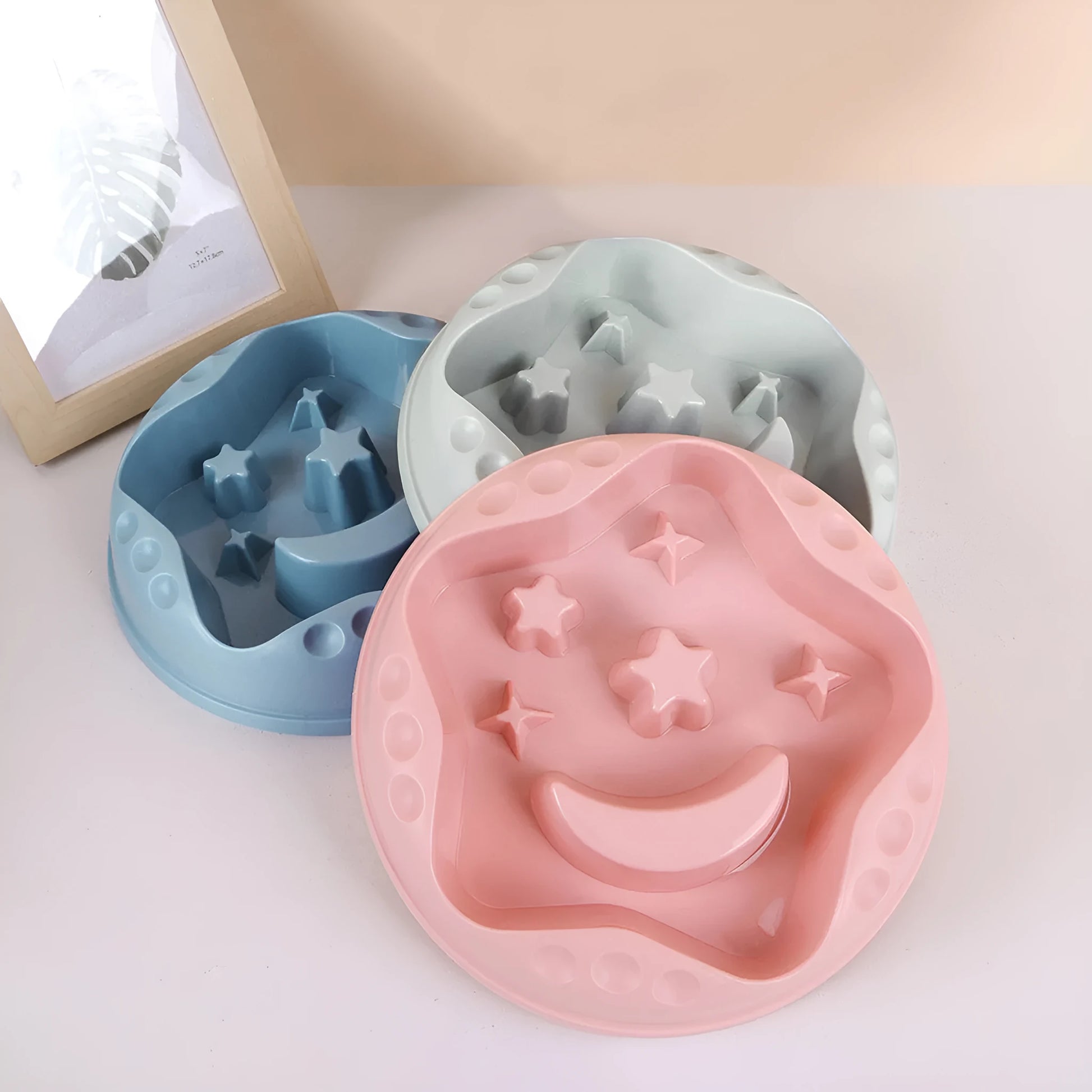 Blue slow feeder dog bowl with raised moon and star patterns inside, non-slip base