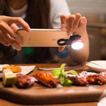 External wide-angle lens and colourful LED light ring attached to a smartphone via a universal mounting clip.