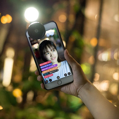 External wide-angle lens and colourful LED light ring attached to a smartphone via a universal mounting clip.