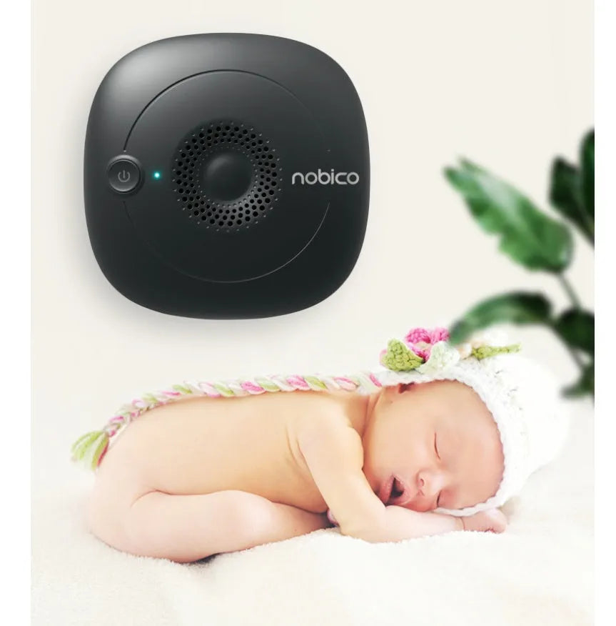 Compact black ultrasonic bed vacuum cleaner for mite repellent on a mattress.
