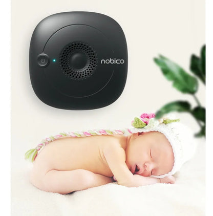 Compact black ultrasonic bed vacuum cleaner for mite repellent on a mattress.