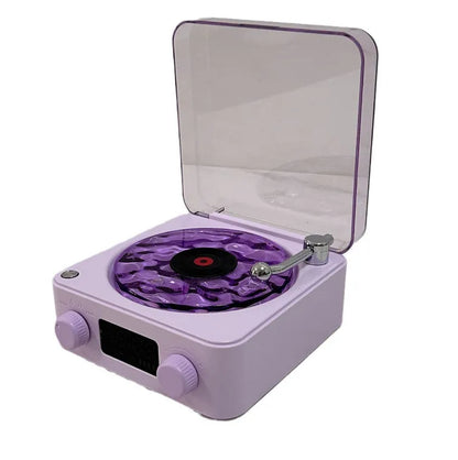 Retro-style turntable Bluetooth speaker with glowing RGB light projection on a wooden surface.