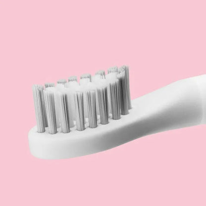 SOOCAS sonic electric toothbrush in blue or pink with round brush head on a bathroom counter.