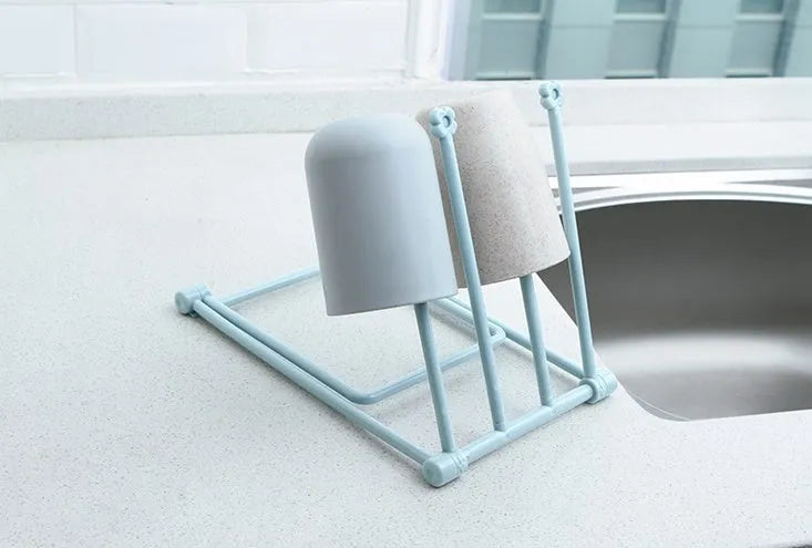 Foldable plastic dishcloth shelf organiser in light blue mounted on a wall.