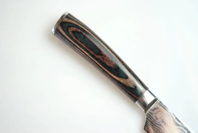 7-inch chef knife with laser Damascus pattern on blade and coloured steel handle on a cutting board.