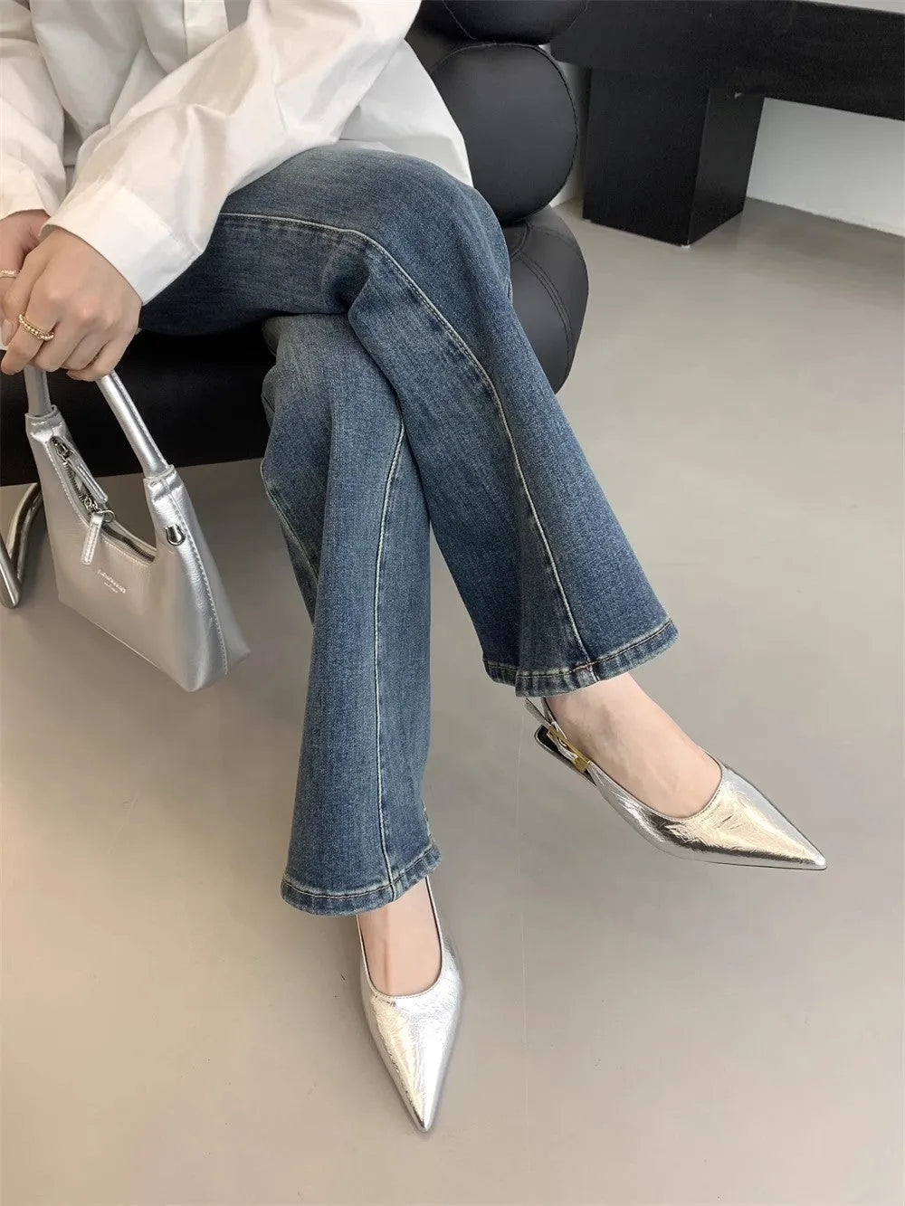 Women's black leather pointed toe shoes with low heel and thin strap.