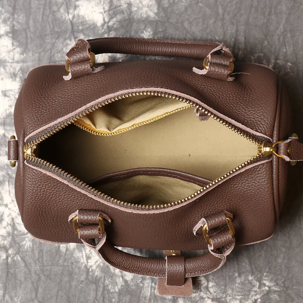 Handmade cylindrical brown Boston bag made from first layer cowhide leather with a single shoulder strap.