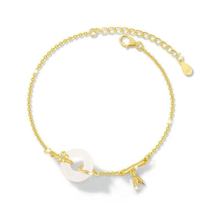 Women's silver and gold electroplated bracelet with peace buckle charm and white chalcedony stone.