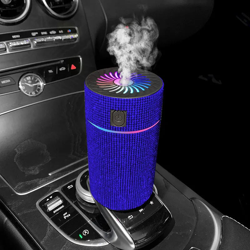 Compact white car air purifier and humidifier unit with USB cable on a car dashboard.