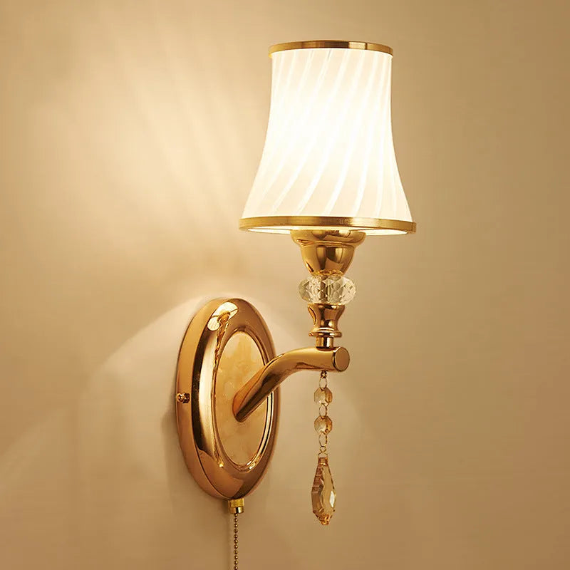 European style wall lamp with glass shade mounted on a wall, showing the cable switch.