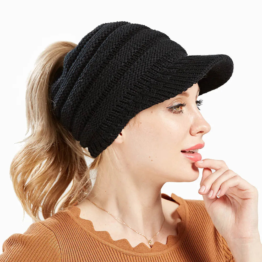 Women's acrylic knitted ponytail beanie in a solid colour, shown on a model with a ponytail.