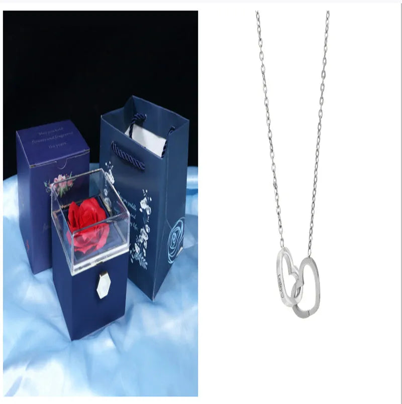 Rotating rose jewellery gift box with a preserved red rose under a clear acrylic dome, showing the interior rotating drawer.