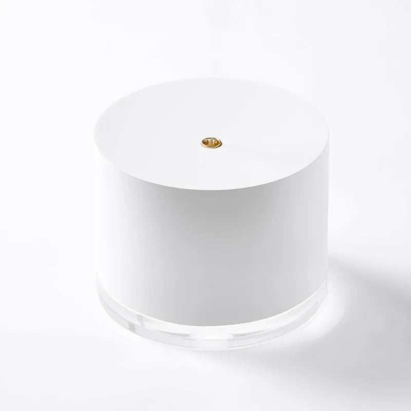 White portable ultrasonic humidifier with LED light and USB charging port on a wooden surface.