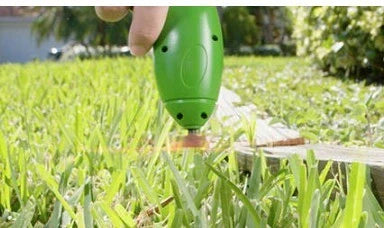 Cordless lawn trimmer with extension pole and debris shield for garden maintenance