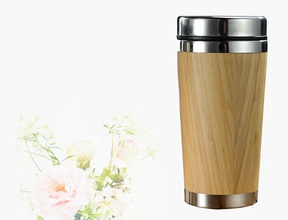 Natural bamboo fibre and stainless steel reusable travel coffee cup with black leak-proof lid on a table