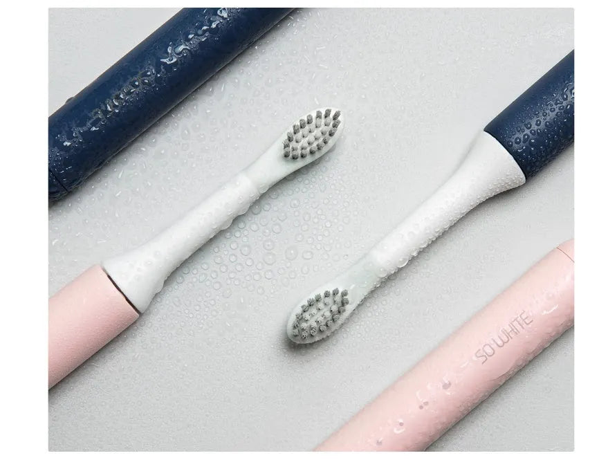 SOOCAS sonic electric toothbrush in blue or pink with round brush head on a bathroom counter.