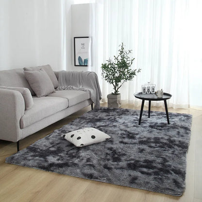Soft fluffy plain rectangle carpet with anti-slip dots on backing, shown in a light grey colour on a wooden floor.
