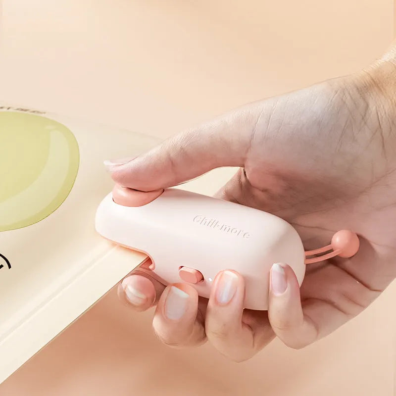 Pink handheld bag sealer machine with USB charging port and cartoon design