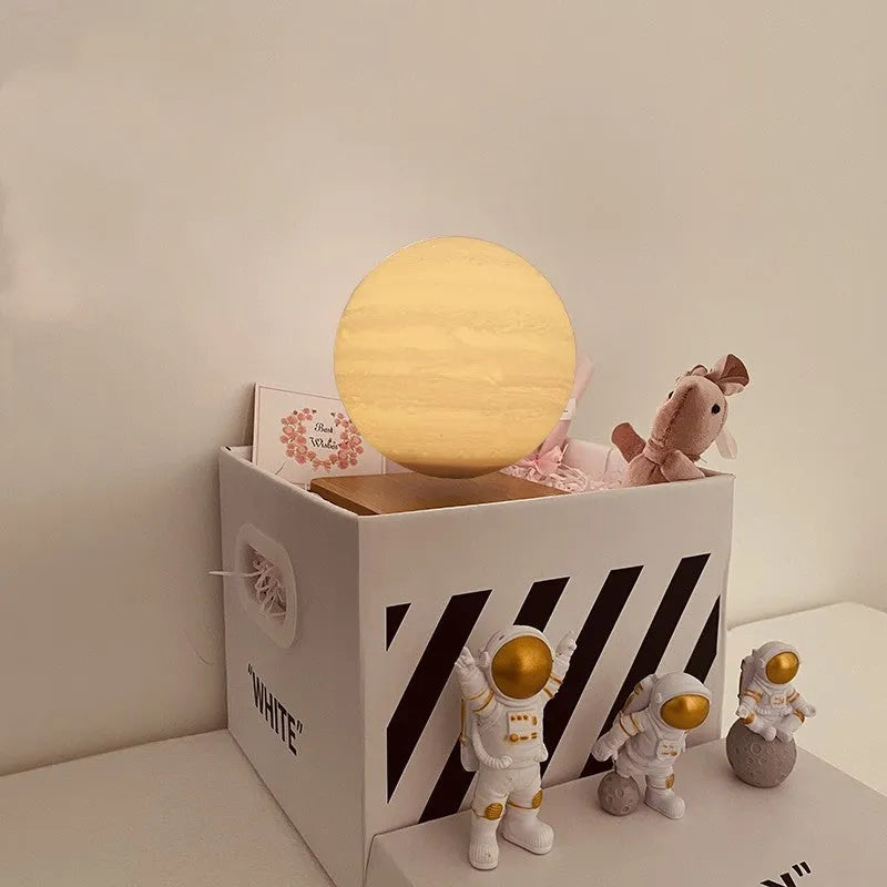 Maglev floating moon planet atmosphere night light with three astronaut figurines on a desk.