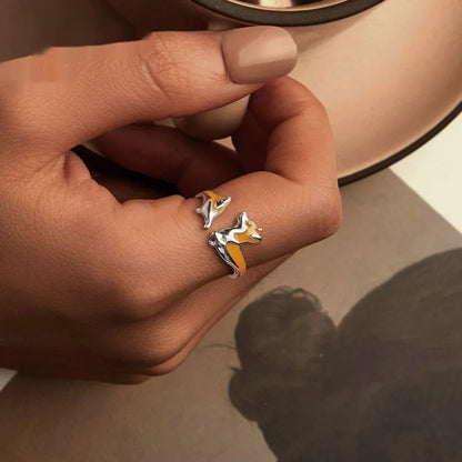 Close-up of an adjustable silver-toned ring with a detailed cartoon corgi dog design.