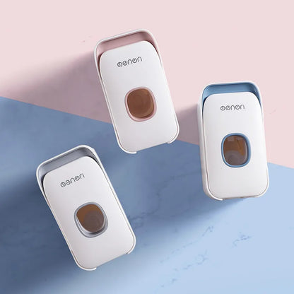 Automatic wall-mounted toothpaste dispenser in blue, grey, and pink colours with LED touch sensor.
