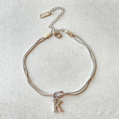 Elegant letter charm bracelets for women in gold and silver tones, featuring a delicate snake chain design and personalised letter charms.