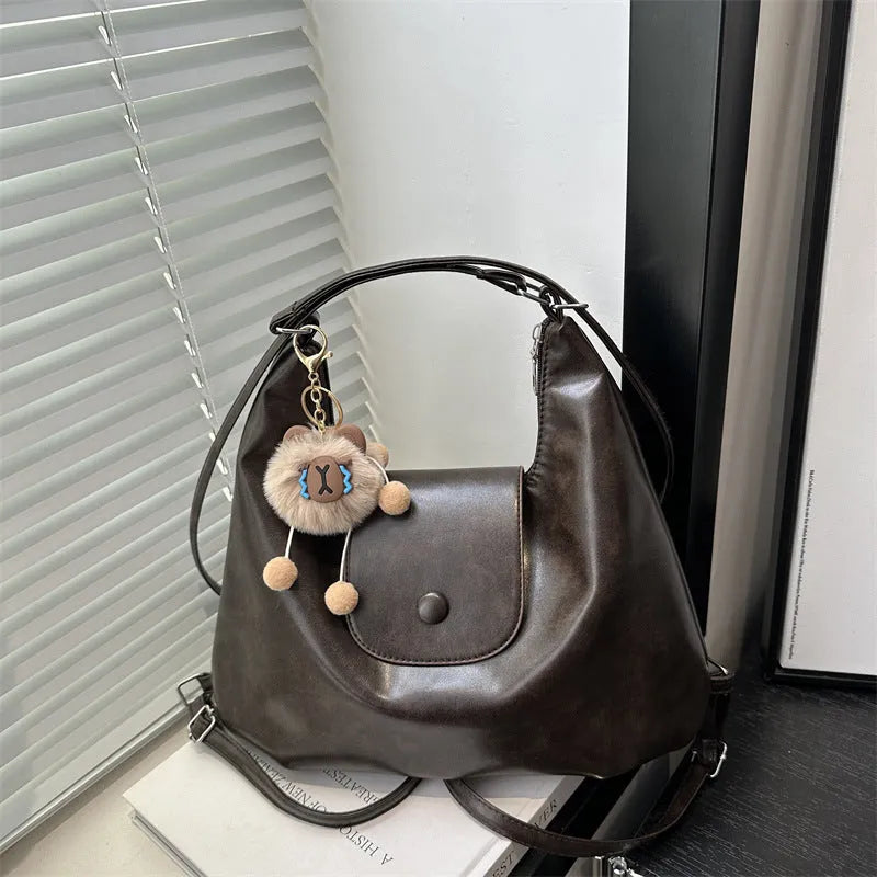 Women's leather shoulder bag single-strap PU medium hardness urban simplicity design large capacity commuter backpack alternative with horizontal square shape in black, brown, or coffee colour with optional pendant accessory