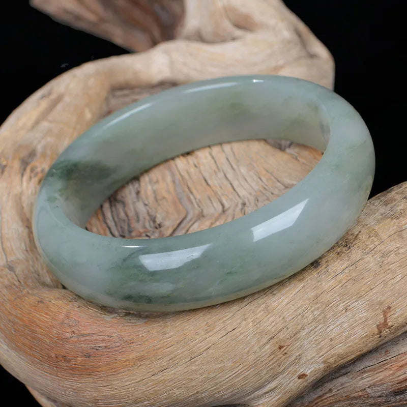 Natural Jinsi Jade Chinese bracelet in a closed bangle design on a plain background.