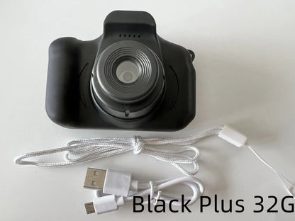 X2 HD mini digital camera for kids in silicone case with lanyard, shown capturing photo on 2-inch screen.