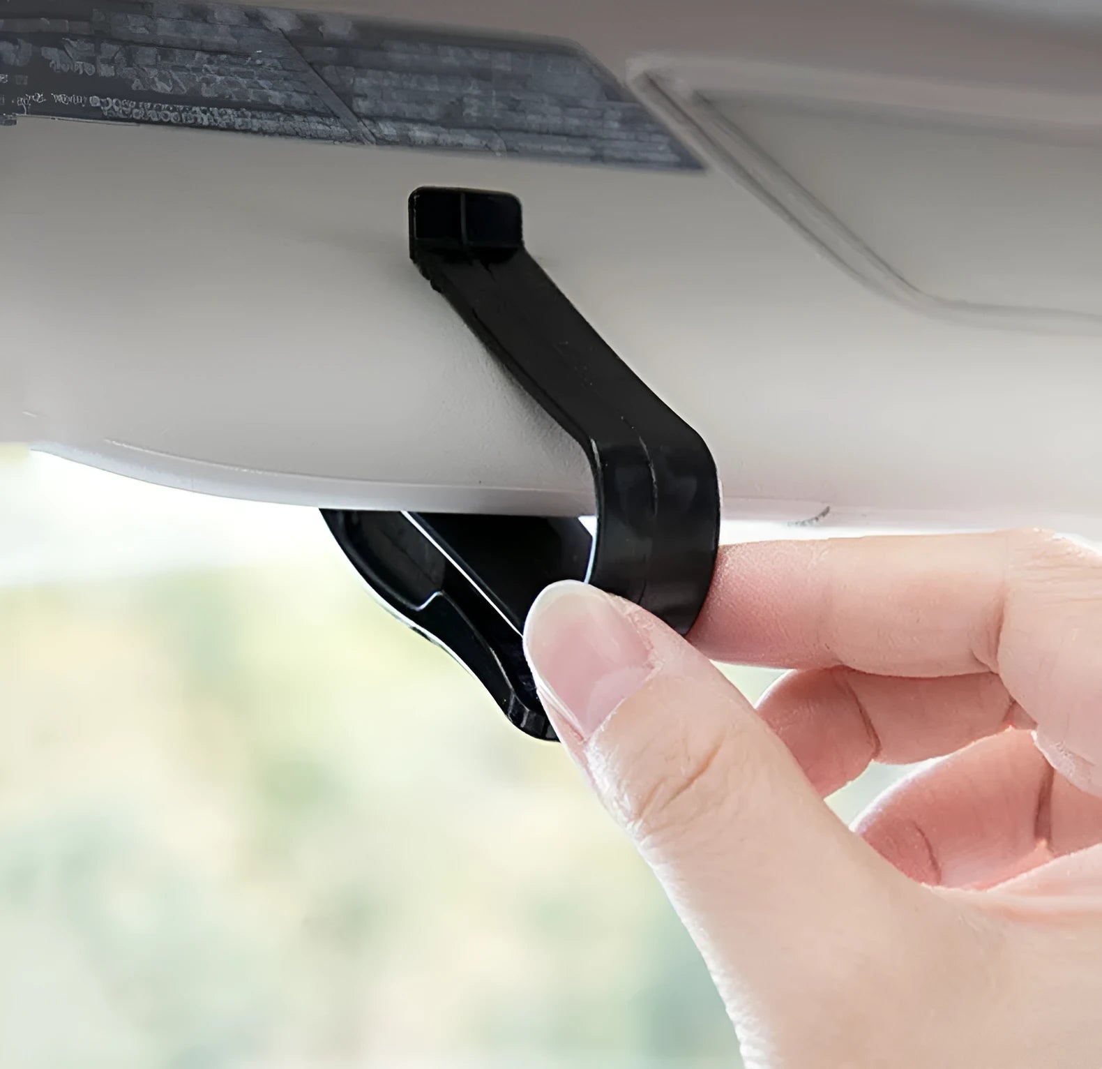 Black plastic clip for car sunshades to hold tickets, ID cards, or glasses.